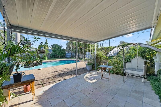 view of patio / terrace featuring a fenced backyard, a shed, an outdoor pool, and an outdoor structure