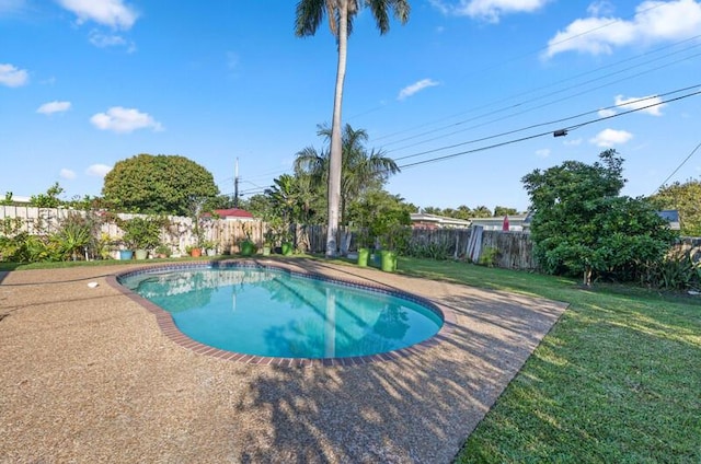 view of swimming pool featuring a fenced in pool, a lawn, a fenced backyard, and a patio area