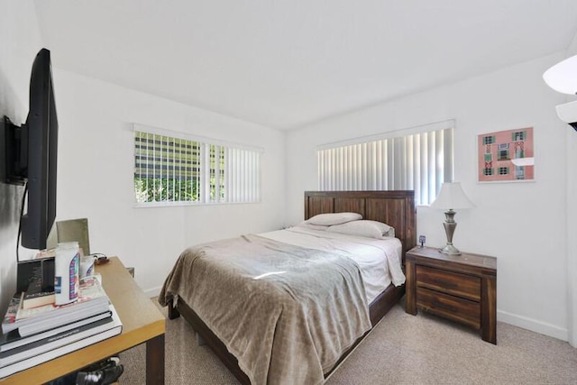 bedroom with baseboards and light carpet