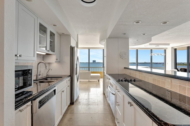 kitchen featuring a sink, plenty of natural light, backsplash, and appliances with stainless steel finishes