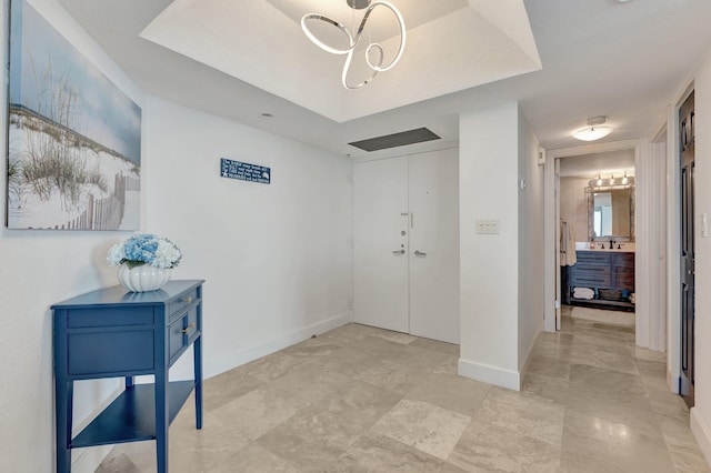 foyer featuring an inviting chandelier and baseboards