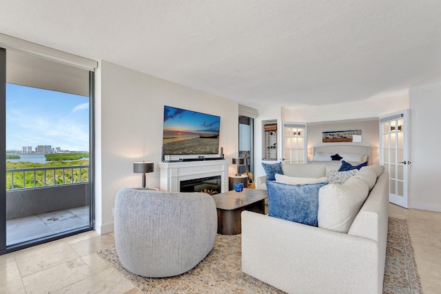 living area featuring a glass covered fireplace and a textured ceiling