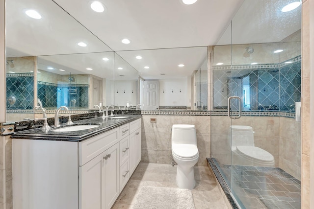 bathroom featuring a shower stall, toilet, tile walls, and a sink