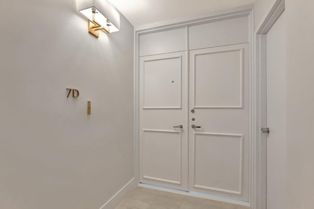 interior space with light tile patterned floors and baseboards