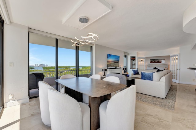 dining area featuring an inviting chandelier and expansive windows