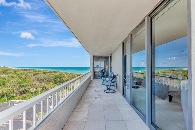 balcony featuring a beach view and a water view