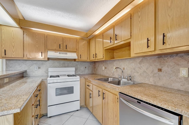 kitchen featuring under cabinet range hood, white range with gas cooktop, stainless steel dishwasher, light tile patterned flooring, and a sink