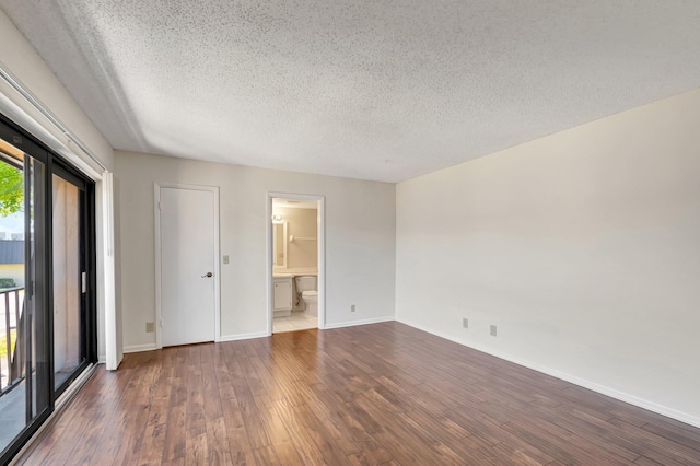 unfurnished bedroom with access to outside, a textured ceiling, ensuite bath, wood finished floors, and baseboards