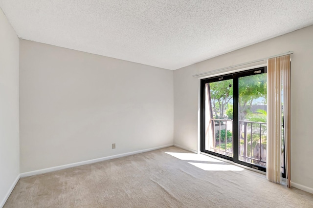 unfurnished room featuring baseboards, a textured ceiling, and carpet flooring