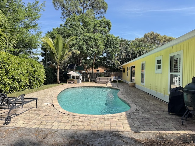 view of pool featuring a patio, fence, a fenced in pool, and a grill