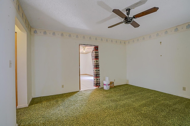 unfurnished room with a textured ceiling, ceiling fan, and carpet flooring