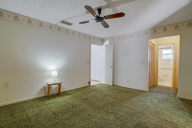 carpeted spare room with a textured ceiling, baseboards, visible vents, and ceiling fan