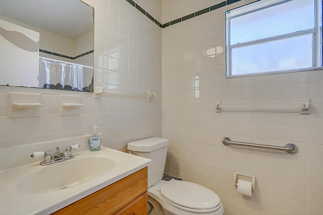 bathroom with curtained shower, toilet, tile walls, and vanity