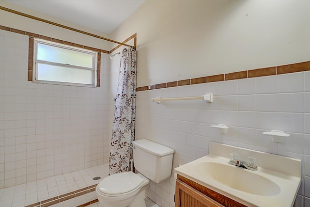 full bathroom with a shower stall, toilet, vanity, wainscoting, and tile walls