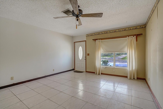 foyer entrance featuring light tile patterned floors, baseboards, a textured ceiling, and a ceiling fan