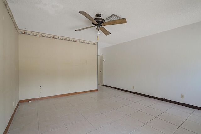 spare room featuring light tile patterned floors, baseboards, a textured ceiling, and a ceiling fan