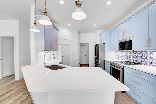 1085 26th St, Vero Beach, FL 32960 - kitchen featuring a peninsula, a sink, stainless steel appliances, decorative backsplash, and blue cabinetry