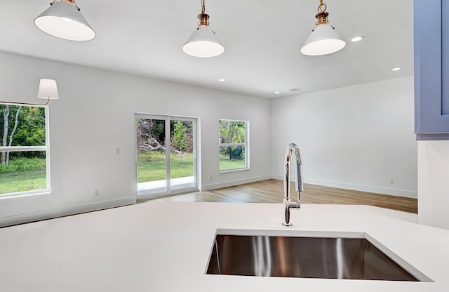 1085 26th St, Vero Beach, FL 32960 - kitchen featuring hanging light fixtures, light countertops, a sink, and wood finished floors
