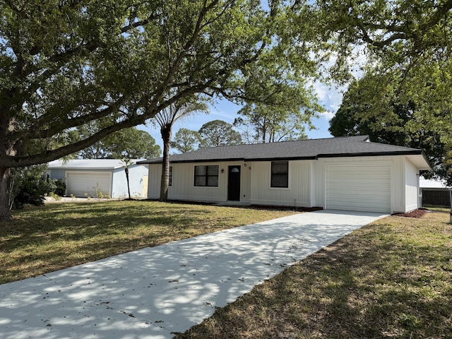 view of front facade featuring driveway, a front yard, and an attached garage