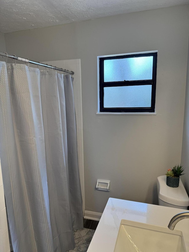 full bathroom featuring tile patterned flooring, a shower with shower curtain, a textured ceiling, and vanity