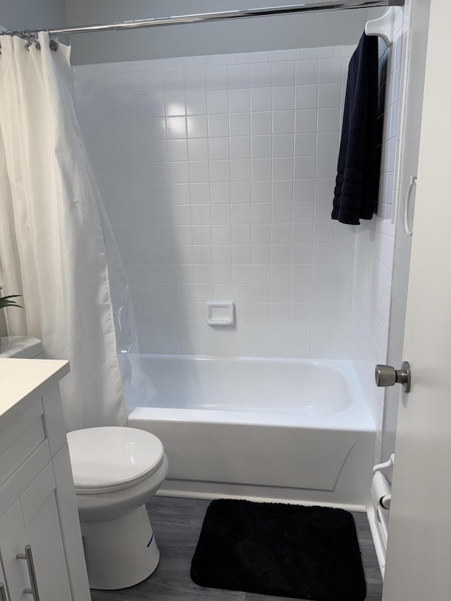 full bath with vanity, shower / tub combo, toilet, and wood finished floors