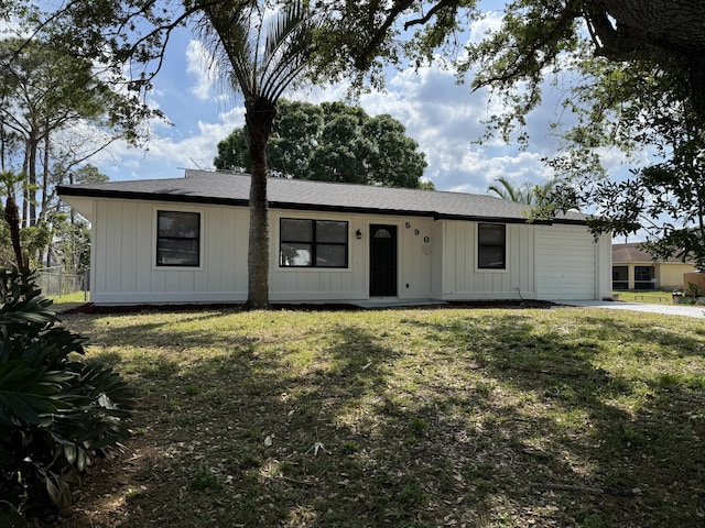 view of front of home featuring an attached garage, a front lawn, board and batten siding, and fence