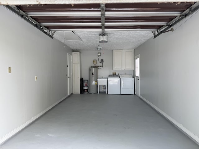 garage featuring baseboards, water heater, separate washer and dryer, a garage door opener, and a sink