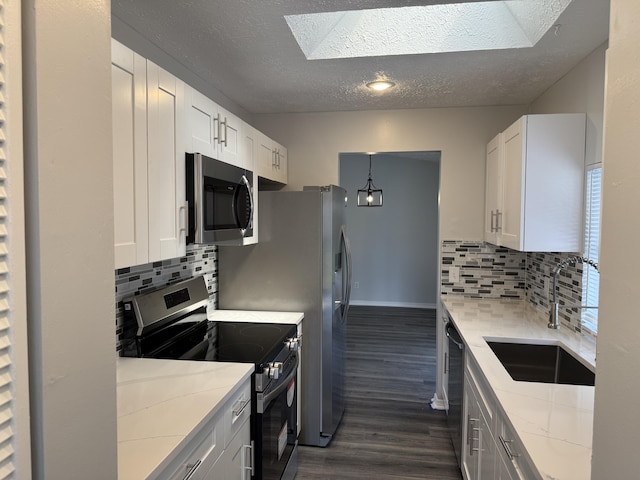 kitchen featuring a sink, backsplash, appliances with stainless steel finishes, and dark wood-style flooring