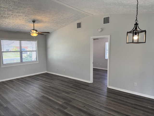 empty room with visible vents, lofted ceiling, and dark wood finished floors