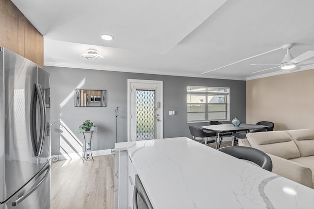 dining room with a ceiling fan, baseboards, light wood finished floors, and ornamental molding