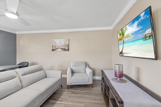 living room with light wood finished floors, baseboards, ceiling fan, and ornamental molding