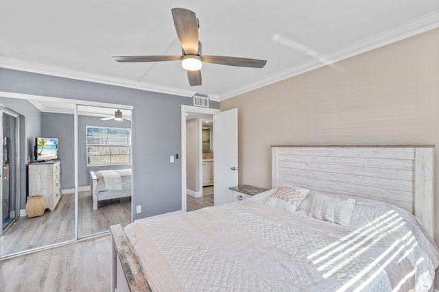 bedroom with a closet, visible vents, ornamental molding, and wood finished floors