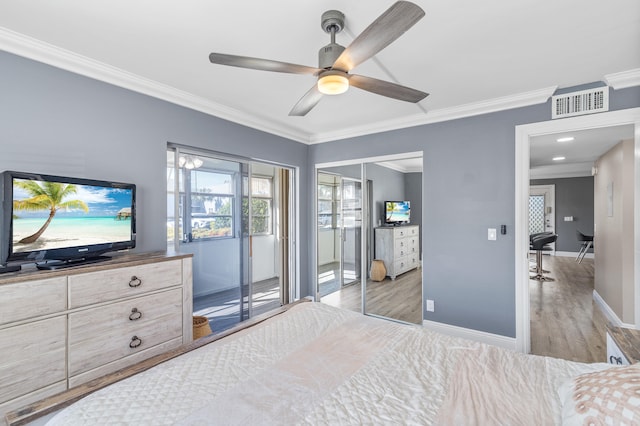 bedroom with baseboards, visible vents, light wood finished floors, ceiling fan, and crown molding