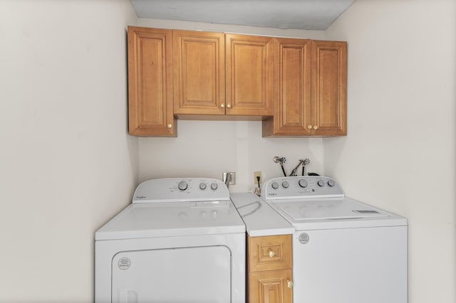 clothes washing area with cabinet space and washer and dryer