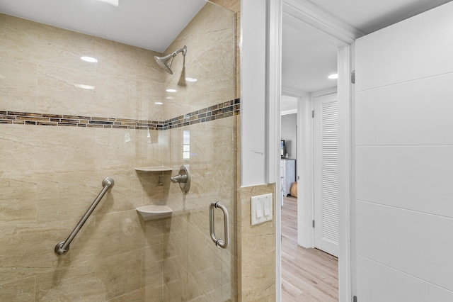 bathroom with wood finished floors and a stall shower