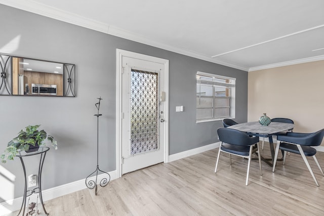 dining room featuring crown molding, wood finished floors, and baseboards