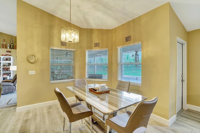 dining area with a chandelier, light wood finished floors, and baseboards