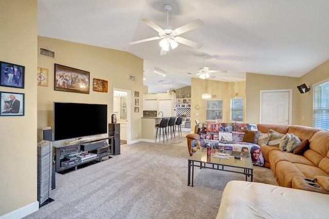 living area featuring a ceiling fan, visible vents, carpet floors, baseboards, and lofted ceiling