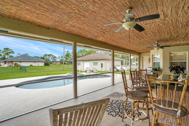 sunroom featuring a ceiling fan