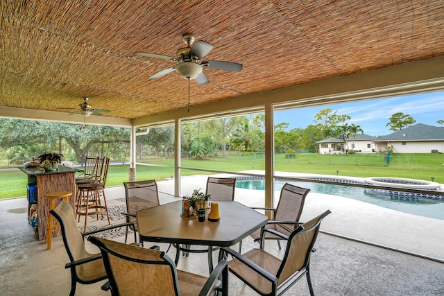 view of patio featuring outdoor dining space, fence, an outdoor pool, a hot tub, and ceiling fan