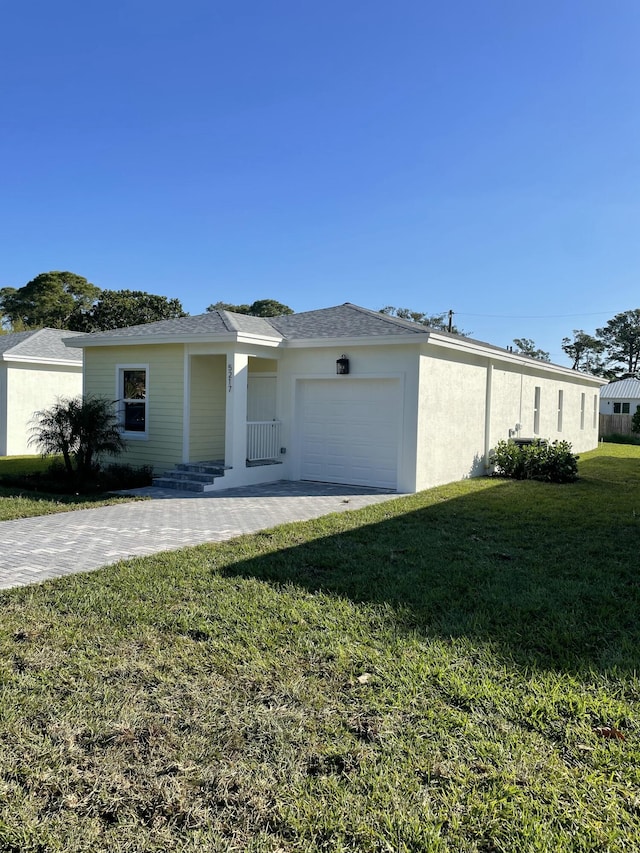 view of front of property with stucco siding, a front lawn, an attached garage, and a shingled roof