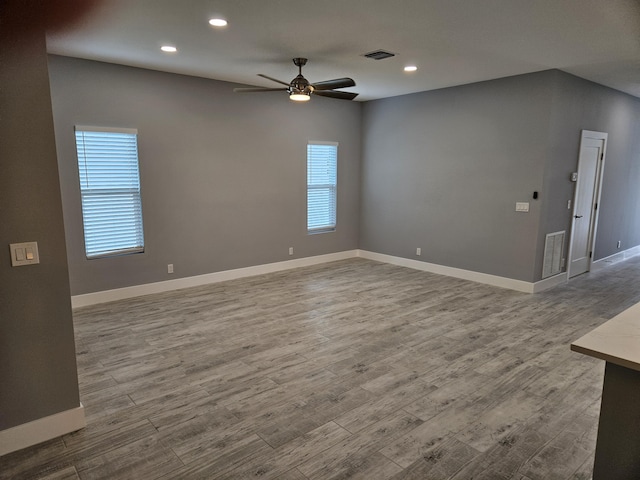 unfurnished living room with visible vents, wood finished floors, baseboards, and ceiling fan