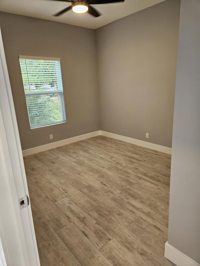 empty room with baseboards, light wood-style flooring, and a ceiling fan