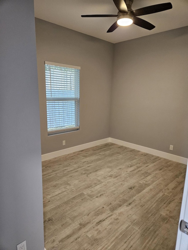 empty room with a ceiling fan, wood finished floors, and baseboards