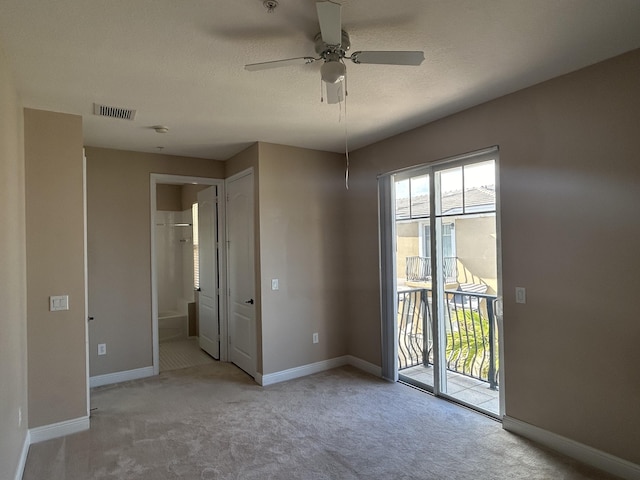 unfurnished room with visible vents, baseboards, light colored carpet, and ceiling fan