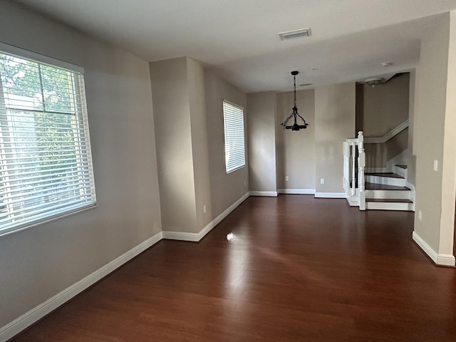 interior space with visible vents, dark wood-type flooring, stairway, baseboards, and a chandelier