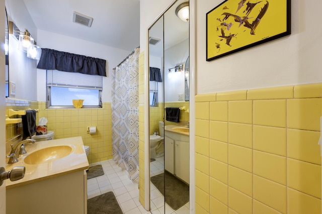 full bathroom with vanity, visible vents, tile patterned flooring, tile walls, and toilet