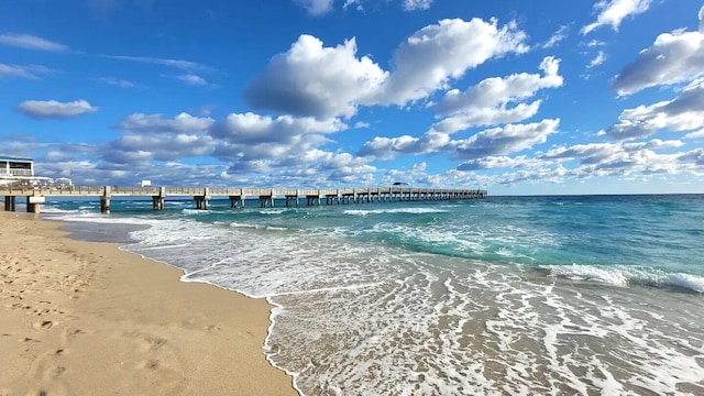 property view of water featuring a pier and a view of the beach