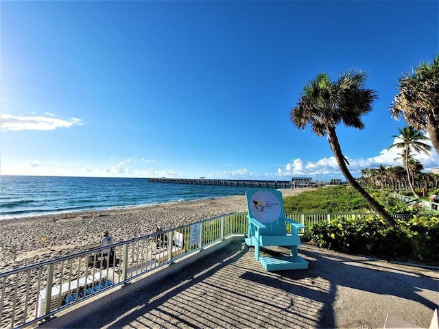 property view of water with a beach view and fence