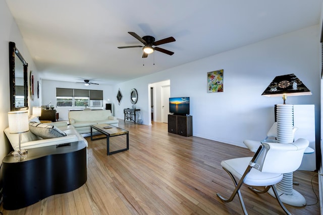 living area with baseboards, light wood finished floors, and ceiling fan